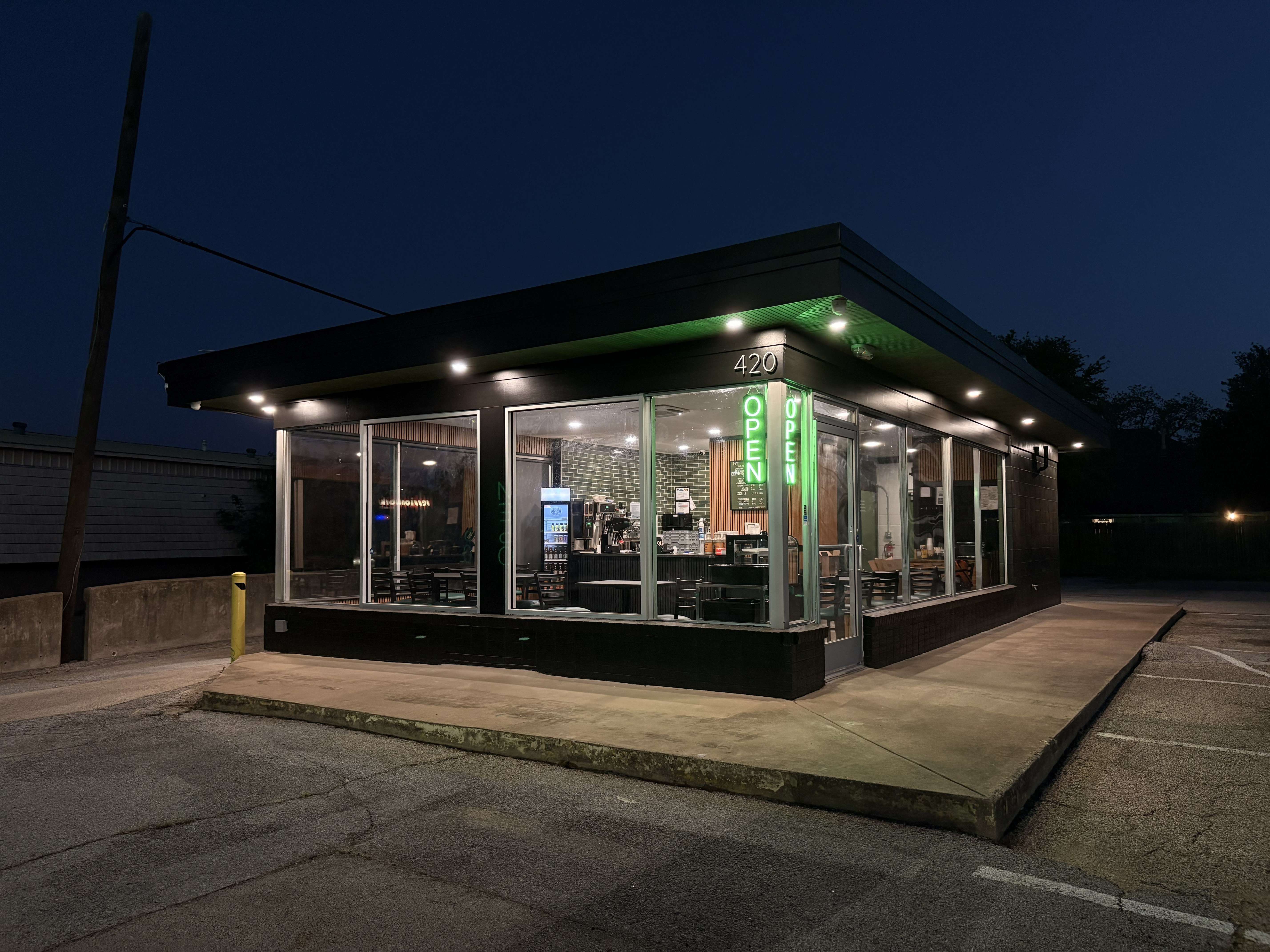 The Coffee Shop lit up at night in Hurst, Texas, with a bright green glowing 420 above the entrance.